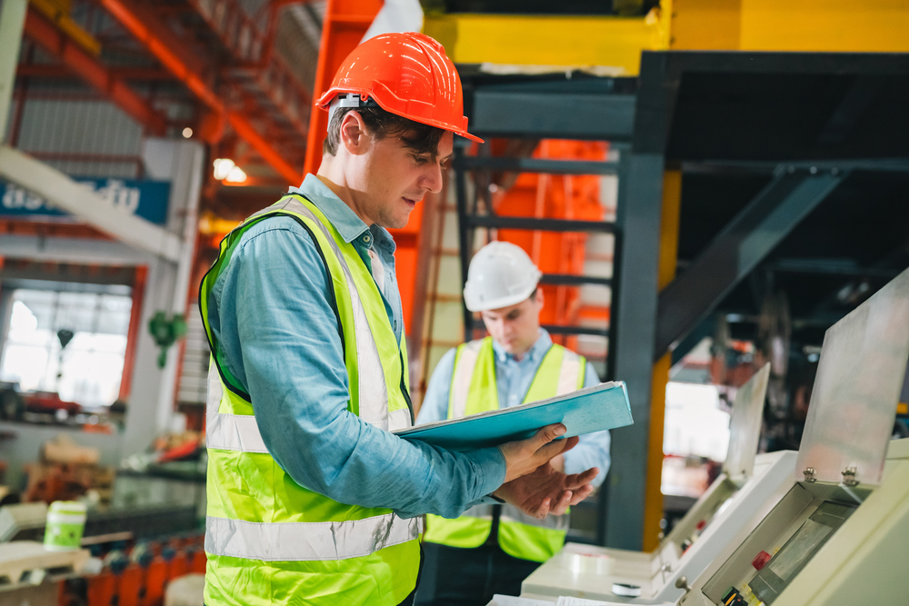 Lavoratori in ambiente industriale consultano documentazione di sicurezza sul lavoro e privacy GDPR