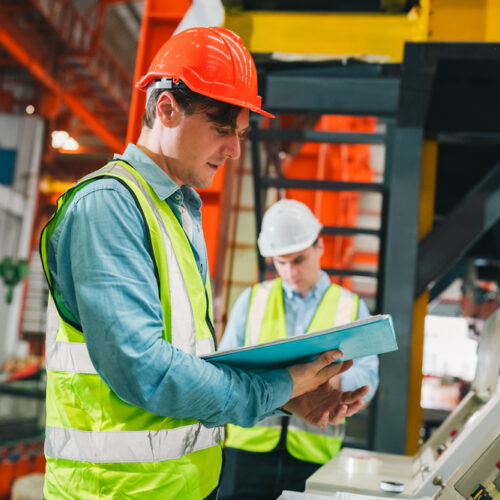 Lavoratori in ambiente industriale consultano documentazione di sicurezza sul lavoro e privacy GDPR